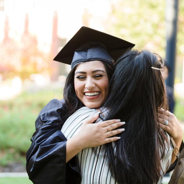 Woman hugging relative celebrating graduation 